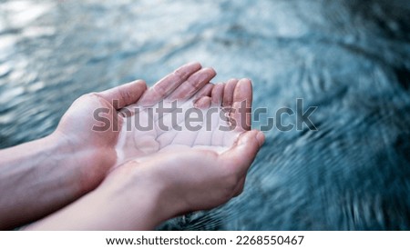 A female hand touching the river water
