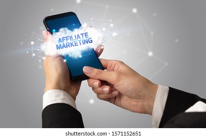Female hand touching smartphone with AFFILIATE MARKETING inscription, cloud business concept - Shutterstock ID 1571152651