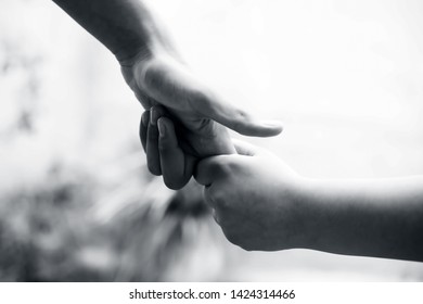 Female Hand Trying To Conquer Her Fears And Obstacles By Holding Male’s Hand. Concept Of Father’s Day And Women’s Day. Horizontal Shot With Bokeh Background. Losing The Grip Of The Elder.