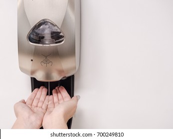 Female hand using automatic machine to get hand sanitizer gel to clean bacteria. coronavirus protection  - Powered by Shutterstock