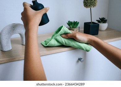 Female hand using microfiber cloth cleaning cupboard surface at home - Shutterstock ID 2366434289