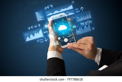 Female hand using smartphone with financial tracking concept illustrated by graphs and symbols - Shutterstock ID 797788618