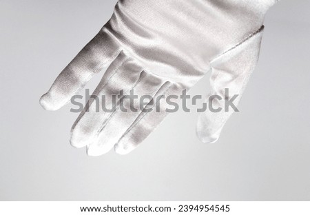 Female hand with white silky glove soft silk satin fashion accessory on white background