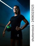 Female handball player cinematic locker room blue backlight misty ball green moody determination strength