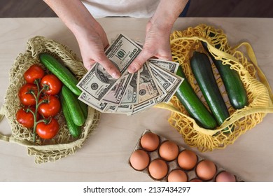 Female Hands With American US Cash Money And Bags With Fresh Produce