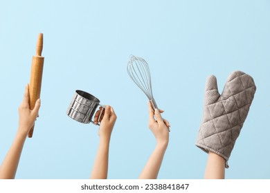 Female hands with baking utensils on blue background