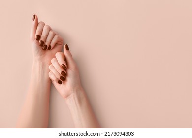 Female hands with beautiful brown manicure on light background