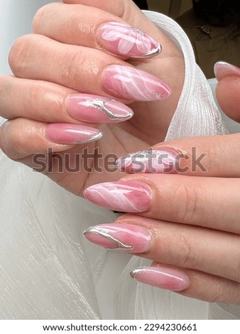female hands with beautiful long almond nails, manicure with nail art design. Fashionable multicolored manicure, marble design
