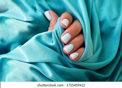 Female hands and beautiful manicure blue background  Summer trend  blue gradient the nails and gel polish  shellac  Short nails