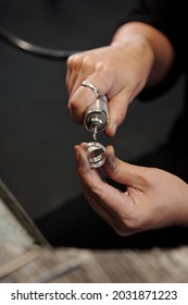 Female Hands Of Bench Jeweler Forming Silver Ring Using Polisher In Workshop