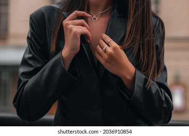 Female hands in a black stylish leather jacket and silver accessories on a female body. Jewelry and women's fashion - Shutterstock ID 2036910854
