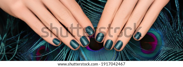 Female\
hands with blue nail design. Female hands with cyan peacock\
feathers. Blue nail polish manicure. Banner\
ad