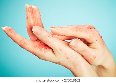 Female hands in body scrub on blue background