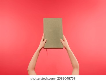 female hands with book isolated on pink background with free space for text