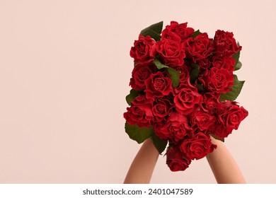 Female hands with bouquet of beautiful red roses on white background. Valentine's day celebration