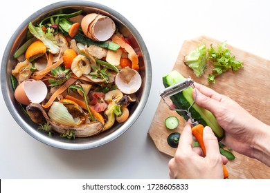 Female hands brush cucumber with knife near iron bowl with organic food waste. Vegetable peelings and food leftovers ready to compost. Ecological, recycling waste concept. - Powered by Shutterstock