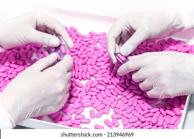 Female Hands Choosing, Controlling The Quality Of A Pills In A Pharmaceutical Factory.Unrecognizable People.Shallow Doff.Macro, Close Up.