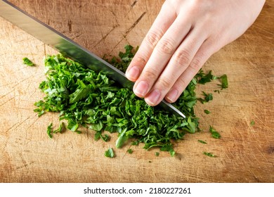  Female hands chopping fresh parsley on wooden board - Powered by Shutterstock