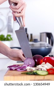 Female Hands Chopping Vegetables On A Wooden Board In The Kitchen