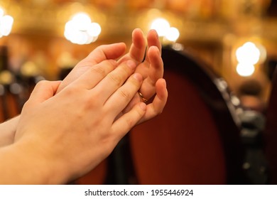 female hands clapping in a theater. warm light