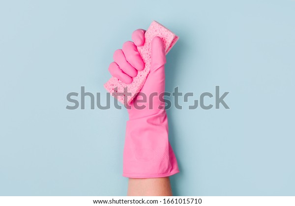 Female hands\
cleaning on blue background. Cleaning or housekeeping concept\
background. Copy space.  Flat lay, Top\
view.