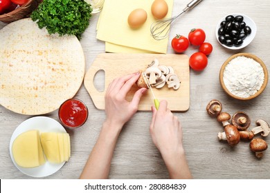 Female Hands Cooking Pizza On Wooden Table, Closeup