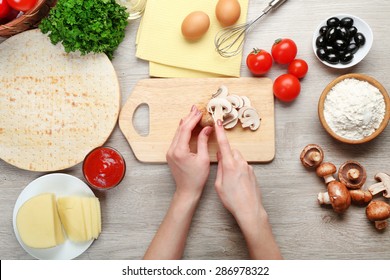 Female Hands Cooking Pizza On Wooden Table, Closeup