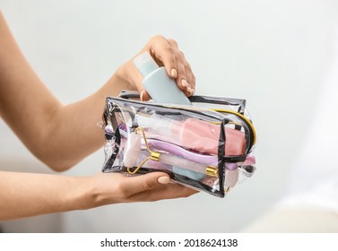 Female Hands And Cosmetics Bag On Light Background