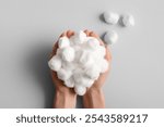 Female hands with cotton balls on grey background