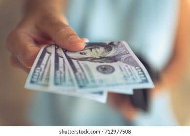 Female hands counting US Dollar bills or paying in cash . - Shutterstock ID 712977508