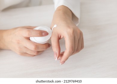 Female Hands With Cream. Woman Applies Cream On Her Hands. Palms Down With Smooth Skin On Hands, Nice Natural Short Nails.