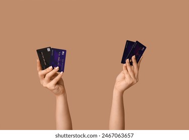 Manos femeninas con tarjetas de crédito sobre fondo marrón