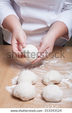Female hands cut up dough. Selective focus.