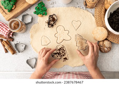 Female hands cut shapes and make Christmas cookies. - Powered by Shutterstock