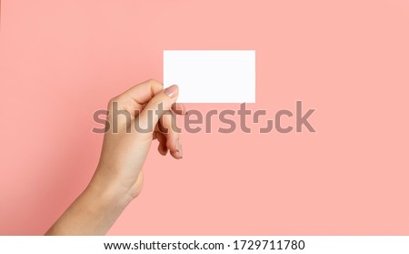 Female hands with cutaway, blank menu, discount card, business card on color pink beauty background with copy space. Template for design Mockup