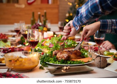 Female Hands Cutting Chicken At Christmas Dinner Table