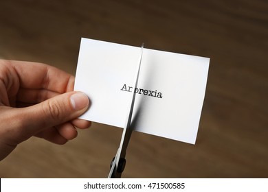 Female Hands Cutting Piece Of Paper With Word Anorexia