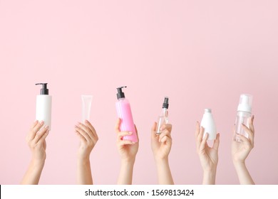 Female hands with different cosmetic products in bottles on color background - Shutterstock ID 1569813424