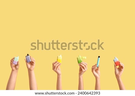 Female hands with different electronic cigarettes on color background