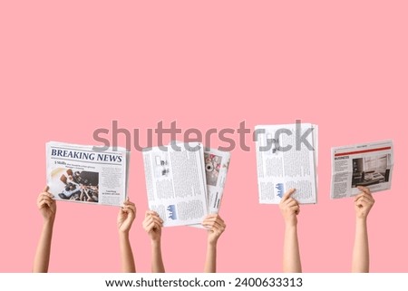 Female hands with different newspapers on pink background