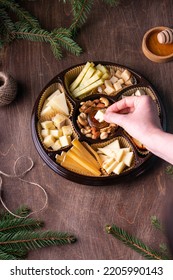 Female Hands Dip Cheese Into Honey On Wooden Background