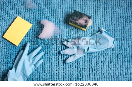  female hands doing spring-cleaning
with latex gloves, sponges and foam

