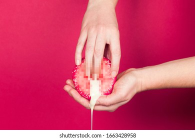 Female hands and a donut on a red background as a symbol of masturbation and foreplay (prelude) before sex. Touch the clitoris, erotic concept.