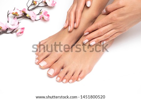 Female hands and feet with nice pedicure isolated on white background.