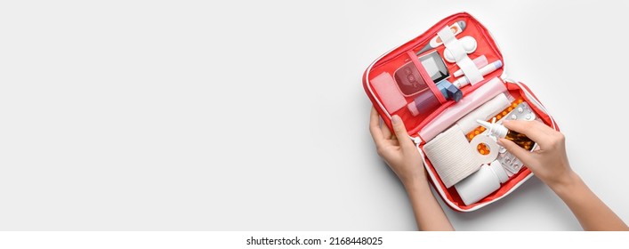 Female hands with first aid kit on light background with space for text - Shutterstock ID 2168448025