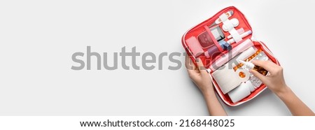 Female hands with first aid kit on light background with space for text 商業照片 © 