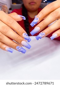 Female hands with flower purple nail. Purple nail polish manicure. Summer nail