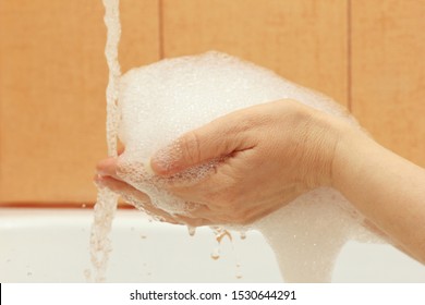 Female hands with foam under the jet of water in the bathroom - Shutterstock ID 1530644291