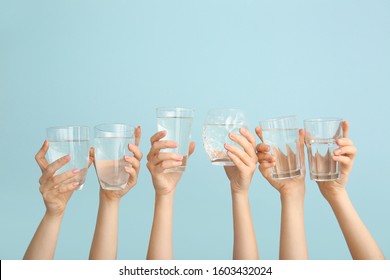 Female Hands With Glasses Of Water On Color Background