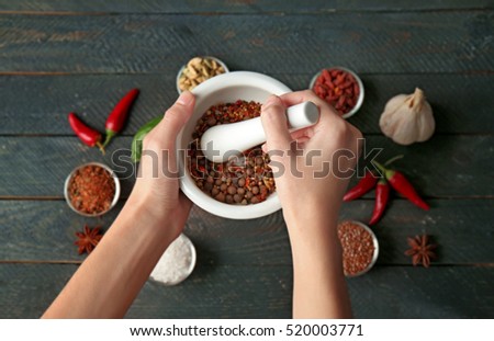 Female hands grinding spices in mortar